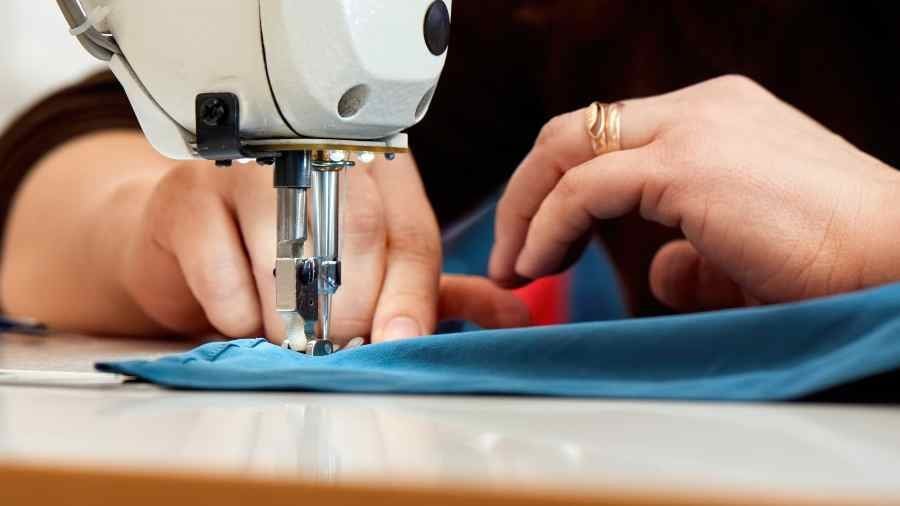 Woman working on a sewing machine with blue cloth