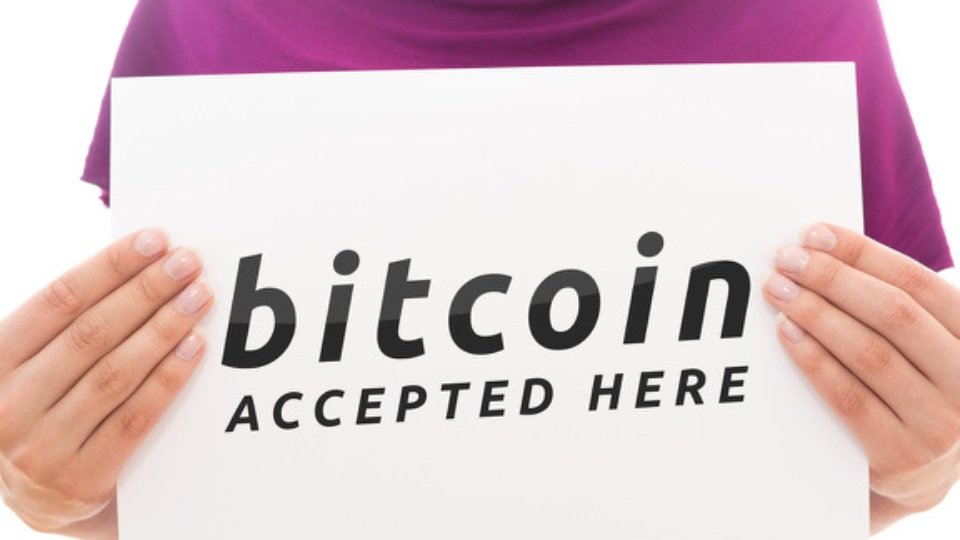Girl holding white paper sheet with Bitcoin logo