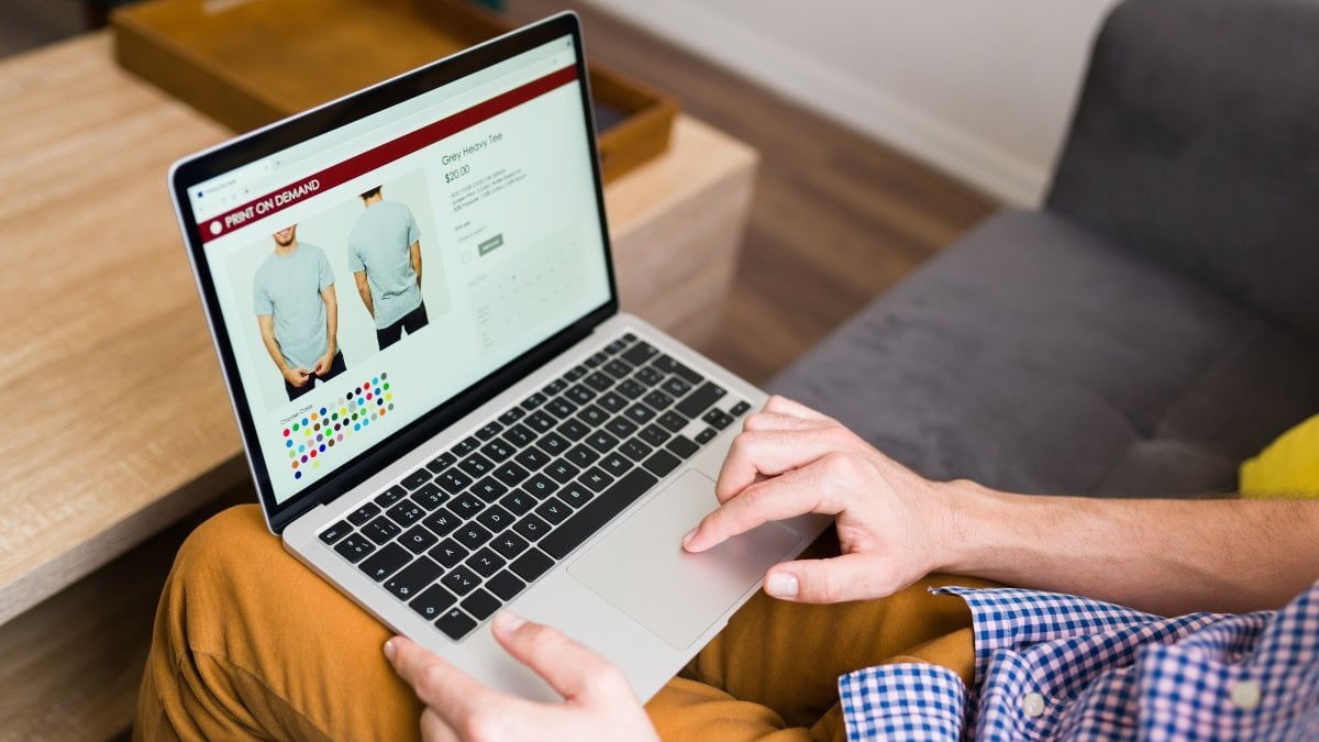 Adult man doing online shopping during a leisure day at home. Young man buying clothes online