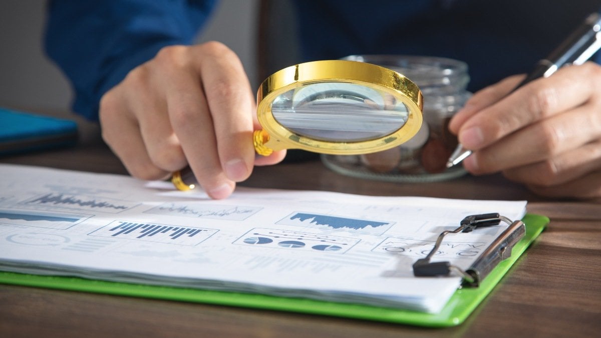 Man holding magnifying glass with a graphs and charts. Business. Analysis