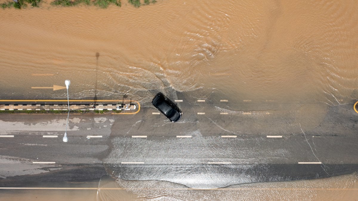 Aerial top view of Flooded the village and Country road with car, View from above shot by drone