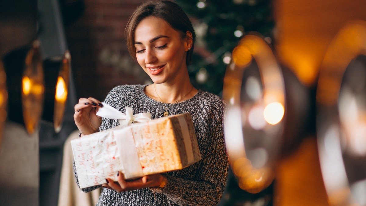 Woman with presents in front of Christmas tree