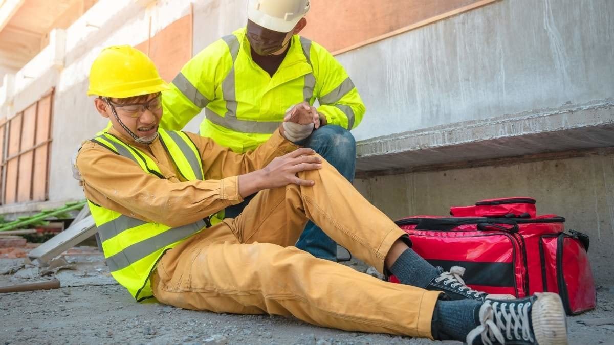Construction worker has an accident at a construction site. Emergency help engineers provide first aid to construction workers in accidents. Safety team help a construction worker who has an accident.