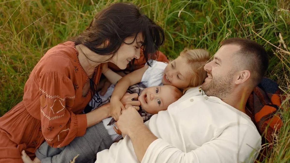 Family with cute little child. Father in a white shirt. Sunset background.
