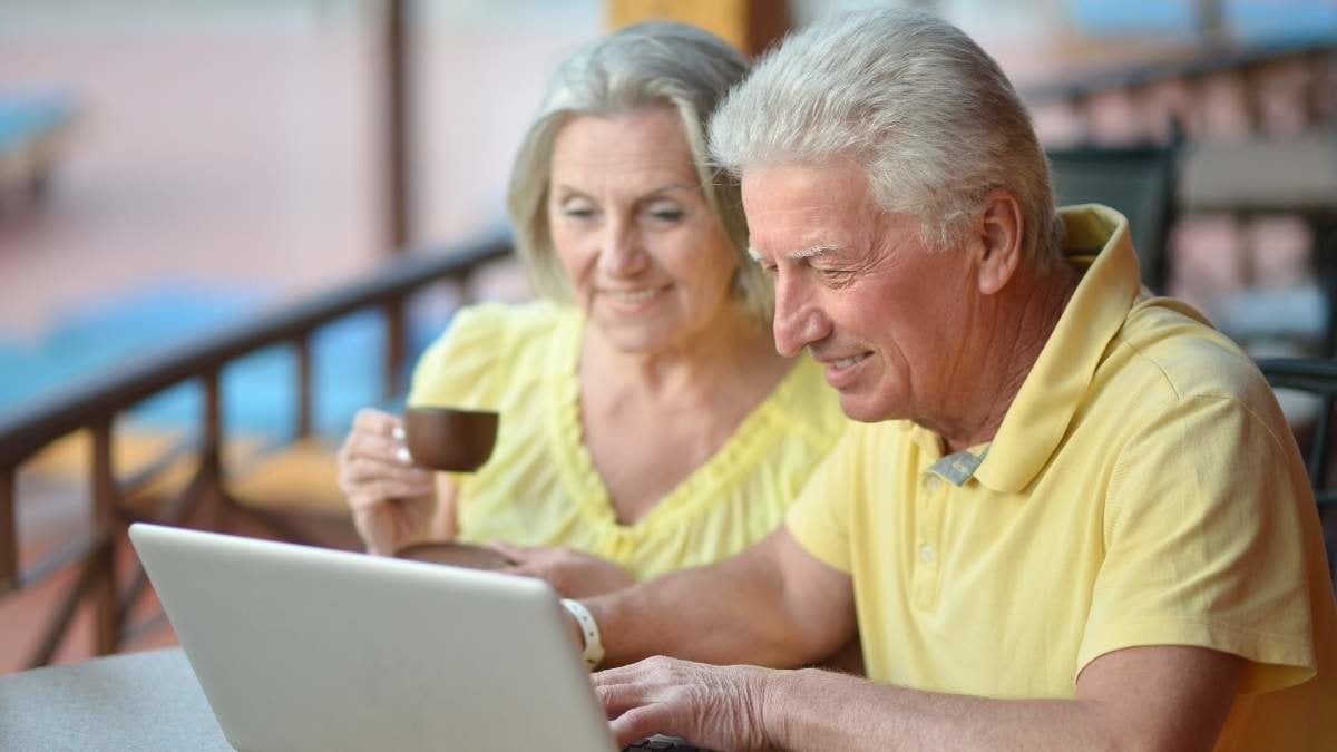 Mature couple sitting with laptop  in hotel