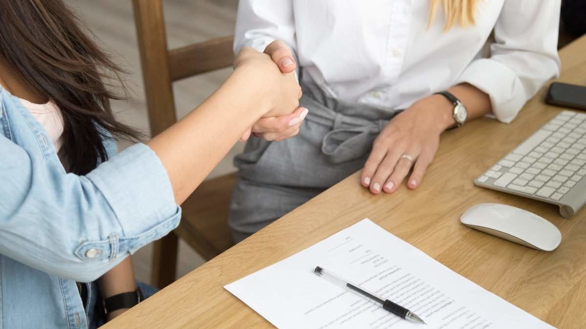 Two women partners handshaking after signing business contract at meeting, female client or customer and manager agent broker closing good deal, female hands shaking making agreement, close up view