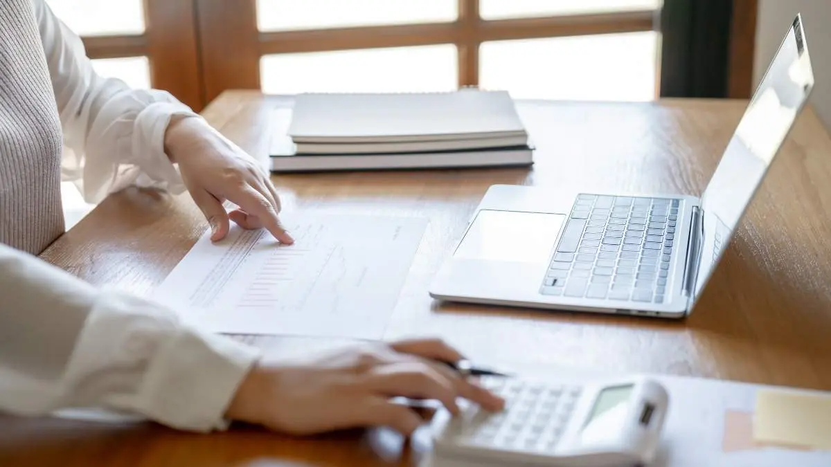 Businesswoman Accountant analyzing investment charts Invoice and pressing calculator buttons over documents. Accounting Bookkeeper Clerk&nbsp;Bank Advisor And Auditor
