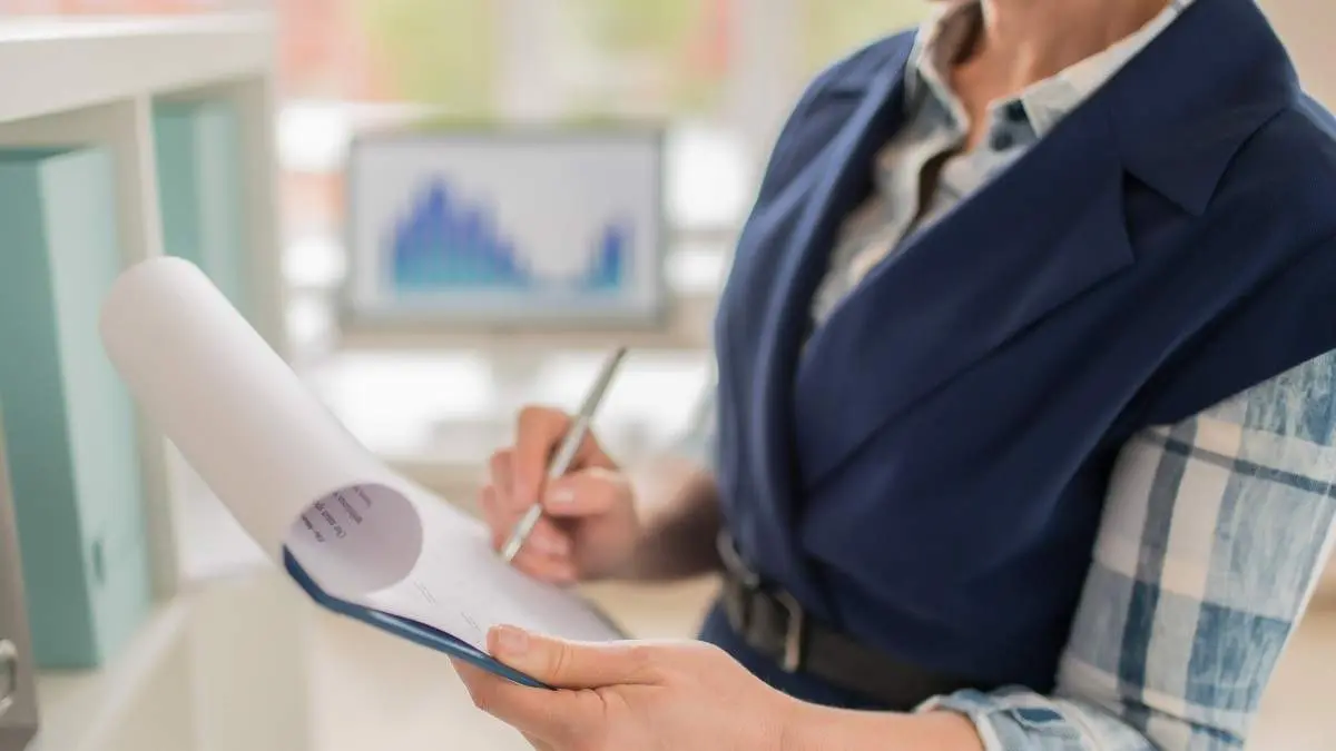 Modern economist signing contract or making notes on paper