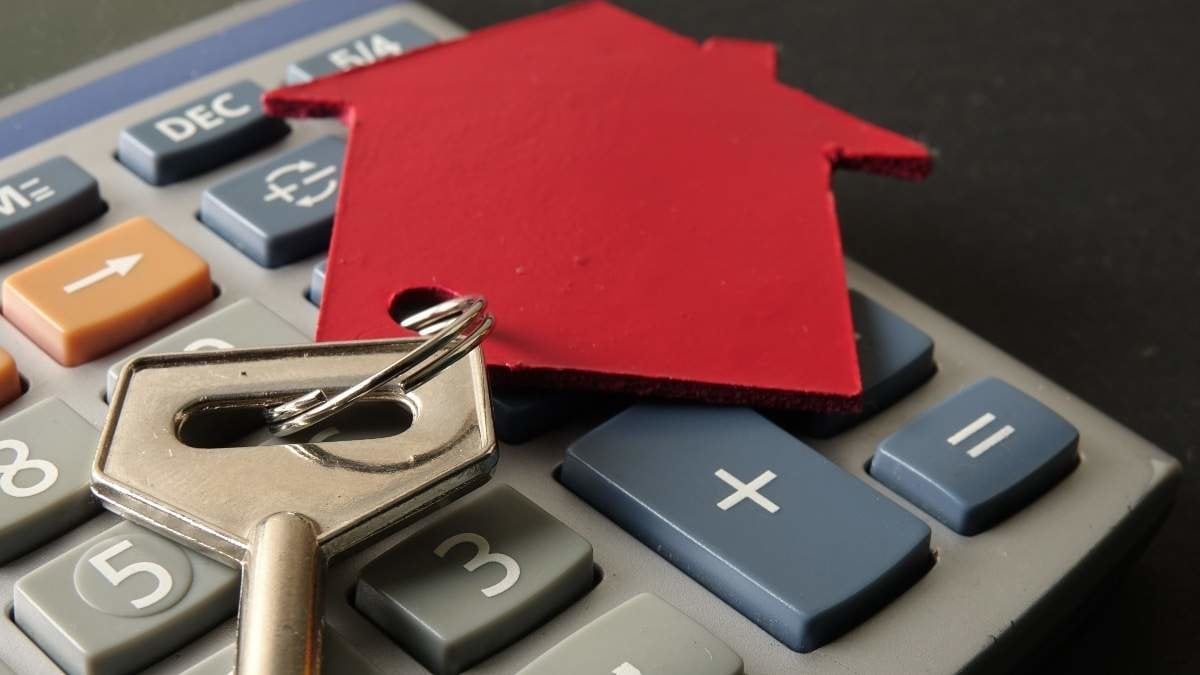 Property/housing ownership concept with red small house and steel key.