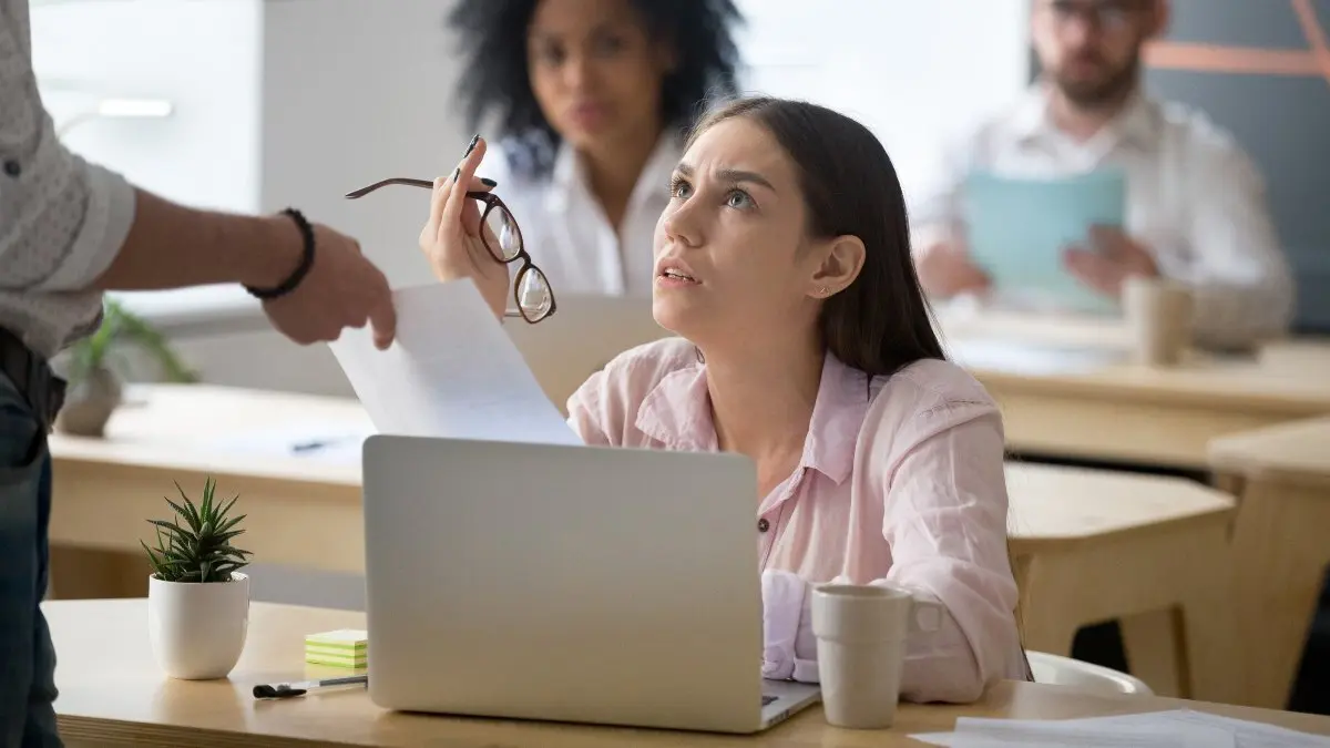 Frustrated employee disagreeing receiving document with bad news or unfair dismissal notice getting fired from job at workplace in coworking office, confused female student shocked being expelled