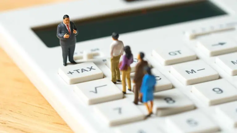 Miniature people Pay queue Annual income (TAX) for the year on calculator. using as background business concept and finance concept with copy space  for your text or  design.