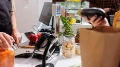 Close up of merchant at checkout counter in zero waste shop selling vegan products to environmentally conscious customers. Client buys healthy food with no additives in local neighborhood store