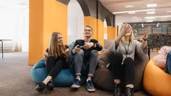 A cheerful team Play video games on the console while relaxing on beanbags after work