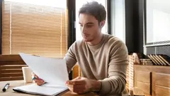 Picture of attractive young man in office working with documents. Coworking.